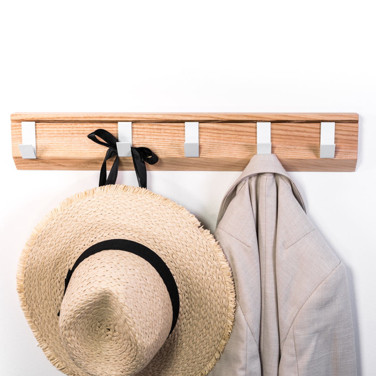 Front view of wall mounted wood hanger with metal hooks