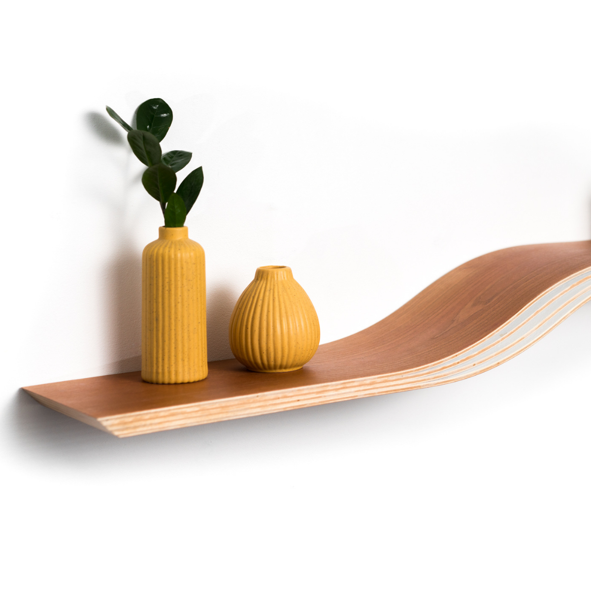 Close-up view of wooden floating wave shelf in cherry wood finish