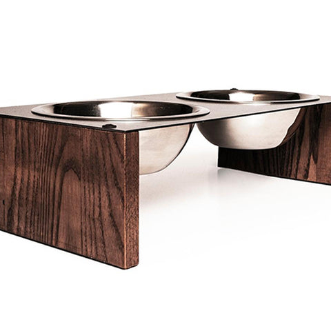 Elevated dog bowl stand with two stainless steel bowls set in a metal top, supported by wooden legs with a rich wood grain texture.