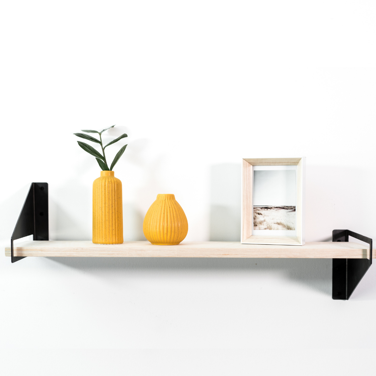 Front view of wooden shelf with geometric metal brackets 