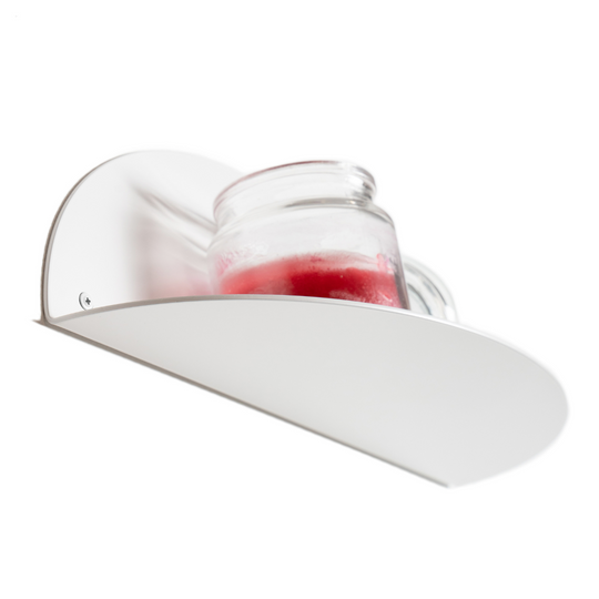 Close-up of a white elliptical metal floating shelf with a candle jar placed on top, showcasing a sleek and minimalist design.