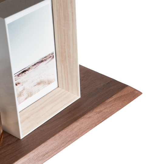 Close-up of the edge of the wood curved floating shelf with solid middle wave section and inclined edges