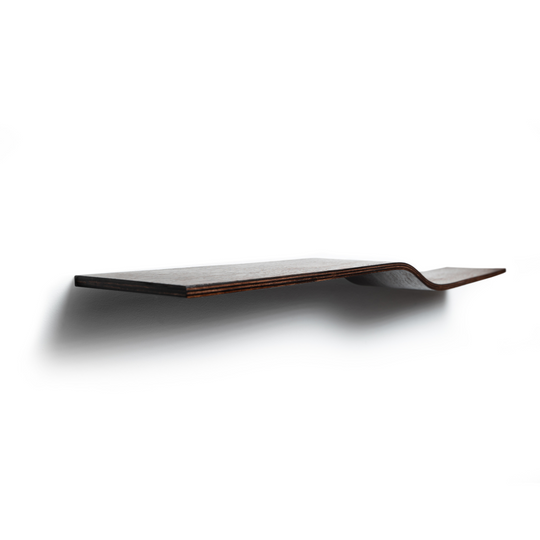Side view of a dark wooden, floating shelf with a slight curve in the middle, mounted on a white wall. The side edge of the shelf is stained, highlighting the natural wood grain.