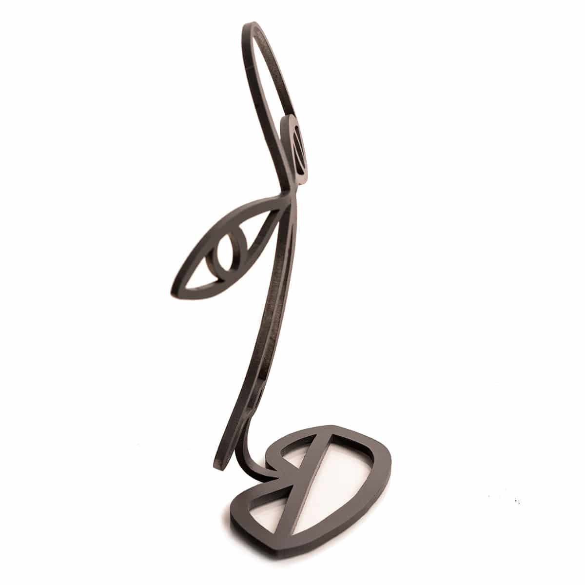 Side view of an abstract black metal glasses stand shaped like a minimalist face, featuring an eye, nose, and lips in a wireframe design.