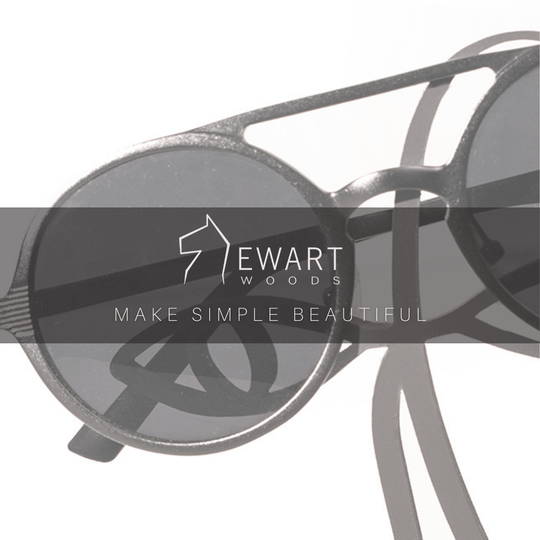 Close-up of a black metal abstract glasses holder with sunglasses placed over the eyes. The &