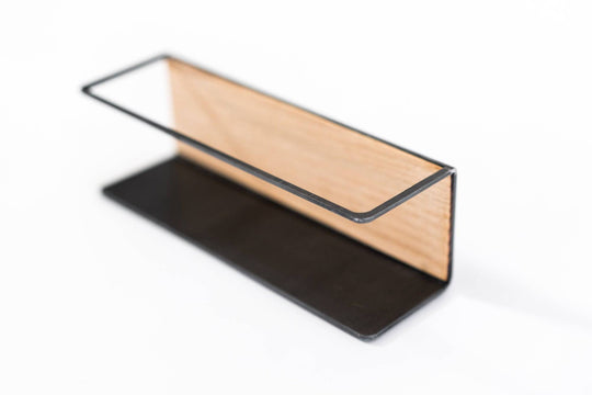 Spice rack with a black metal frame and a wooden back, featuring a sleek and simple design, ideal for organizing spices in a stylish and functional manner.